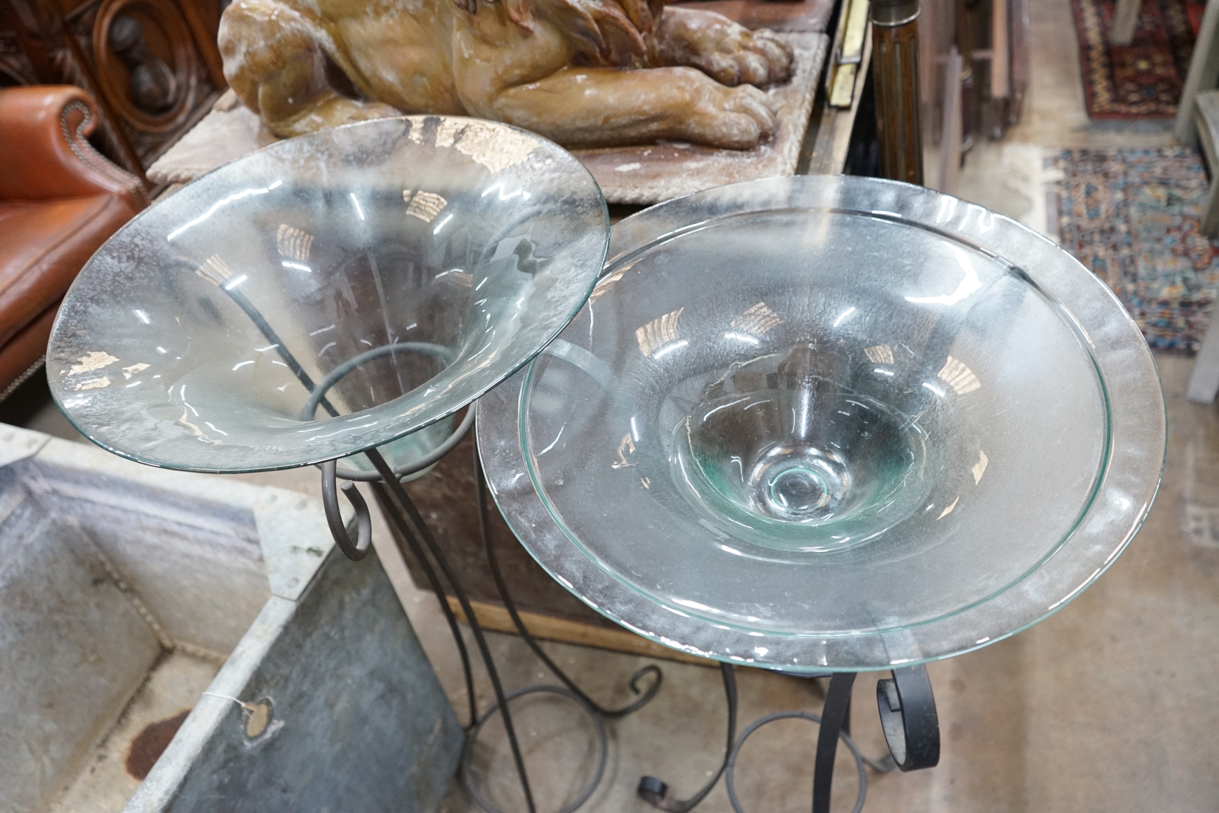 A near pair of circular glass bowls on wrought iron stands, tallest 103cm